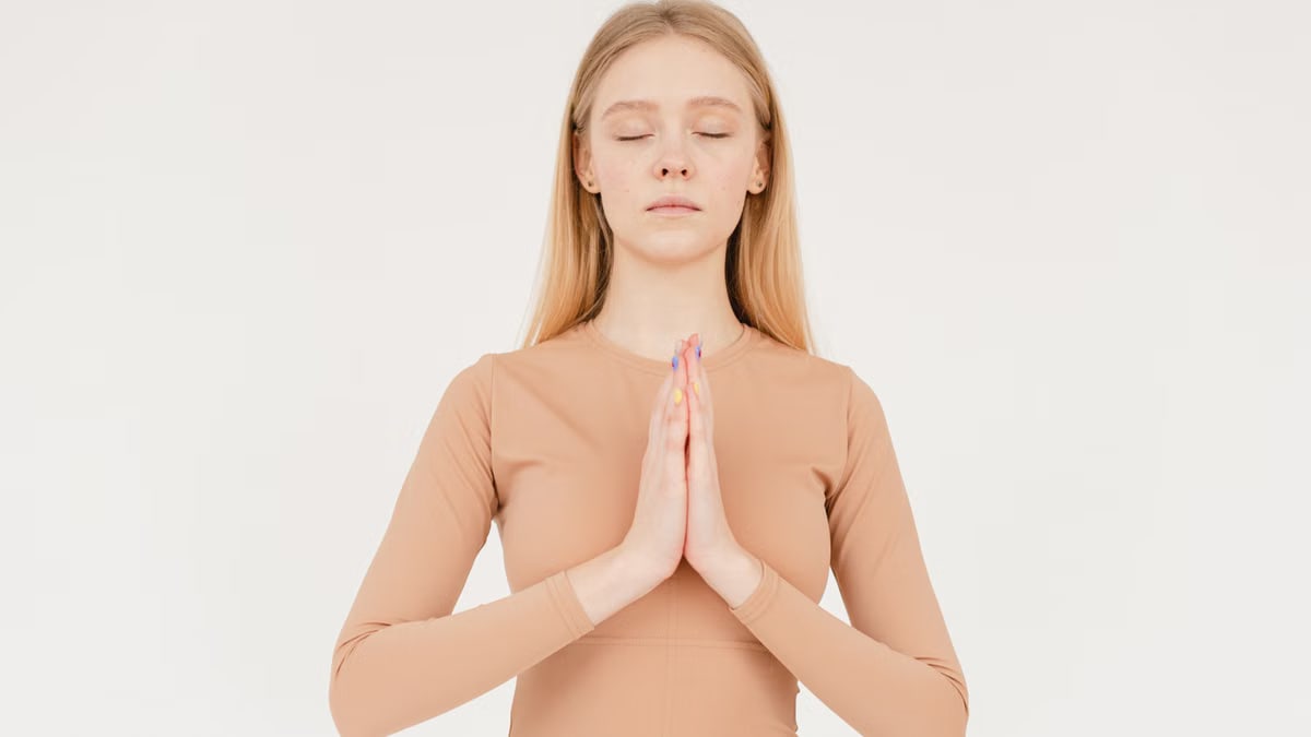 Woman practicing meditation with eyes closed, focusing on inner peace.